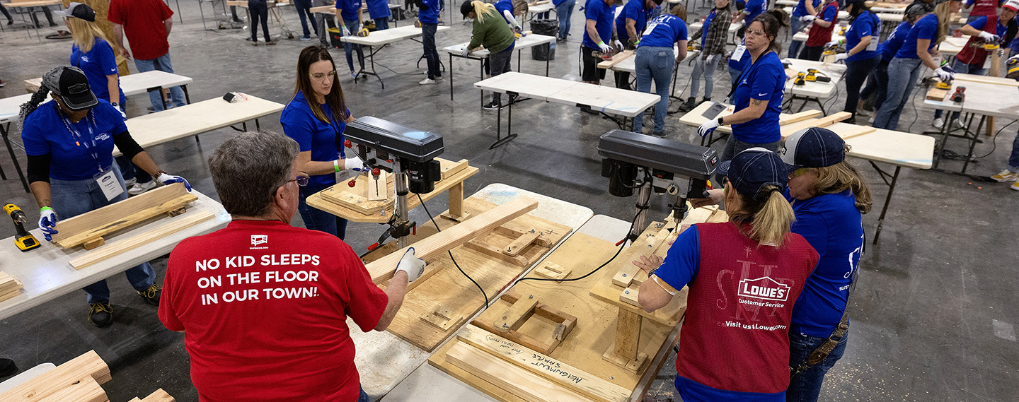 Lowe's employees their spouses and volunteers building beds for kids in need. 
